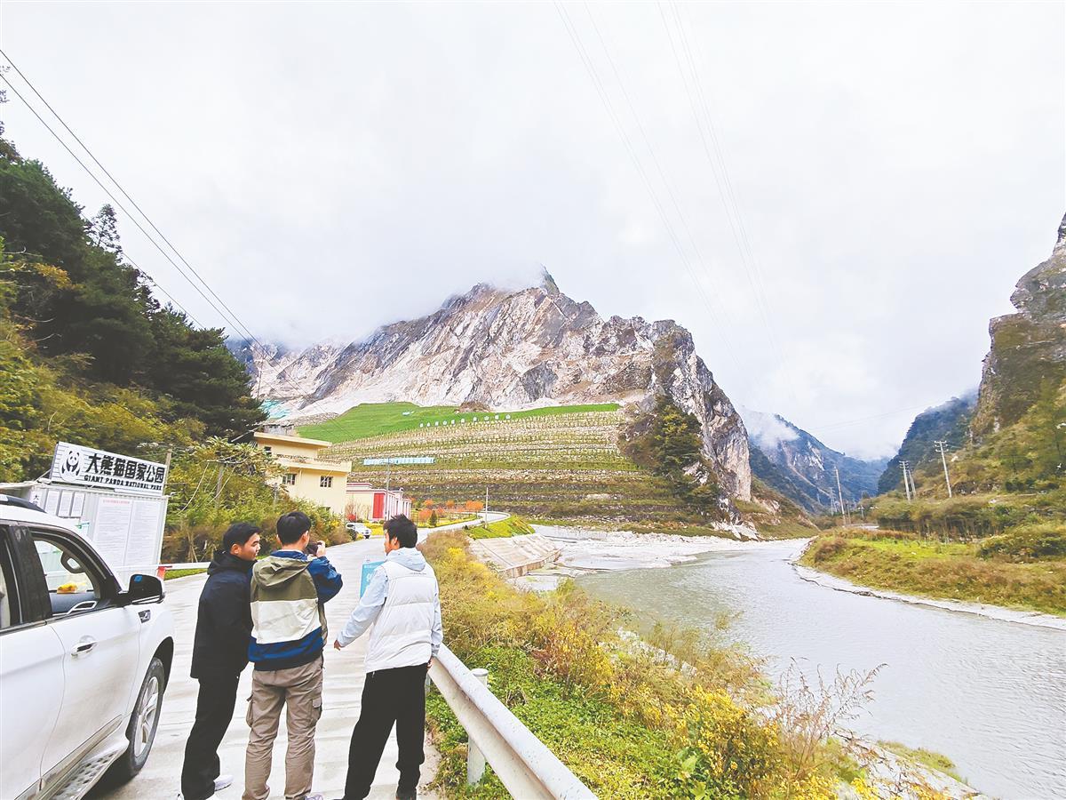 地大师生在雅安市宝兴县作地质调查，前方是高耸的汉白玉山体。