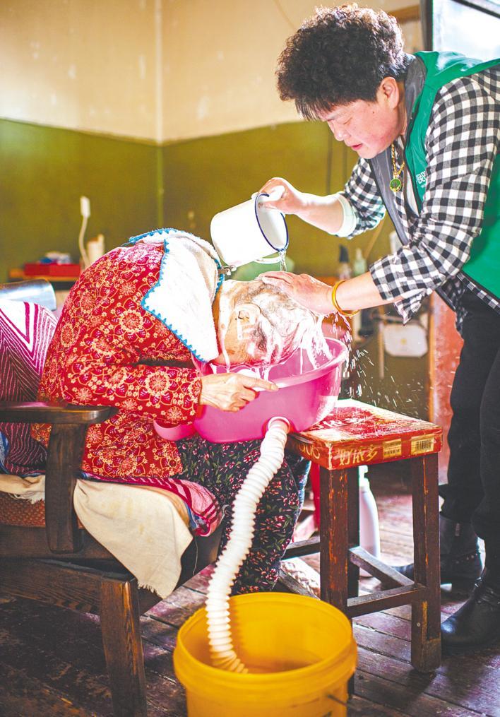 3月12日，照护师朱春华上门帮张慧芬老人洗头理发。